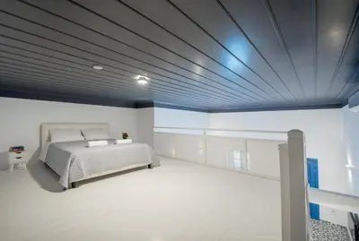 a bedroom with a bed and a blue ceiling at Porto Harani Seaside Apartments in Symi
