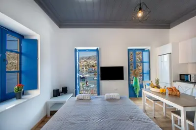 a living room with a large bed and a table at Porto Harani Seaside Apartments in Symi