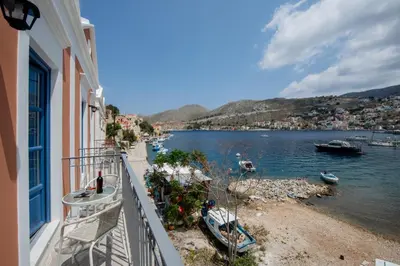a balcony of a building with a view of a body of water at Porto Harani Seaside Apartments in Symi
