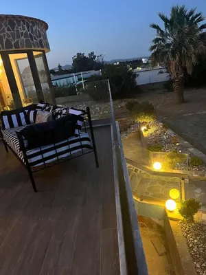 a bench on a balcony with a view of the ocean at Villa Eleni-Gennadi in Yennadhion