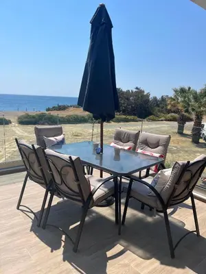 a table and chairs with an umbrella on a patio at Villa Eleni-Gennadi in Yennadhion