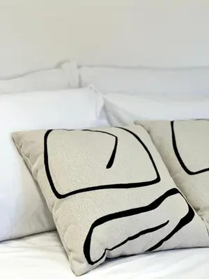 a black and white blanket on a bed with two pillows at Stone Steps Studio in Symi