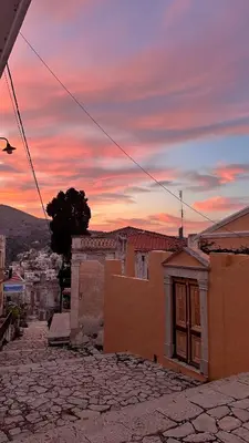 a view of a city with a sunset in the background at Stone Steps Studio in Symi