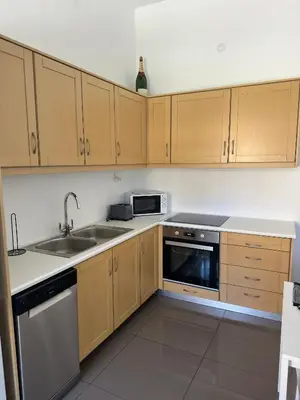 a kitchen with wooden cabinets and a sink at Stone Steps Studio in Symi