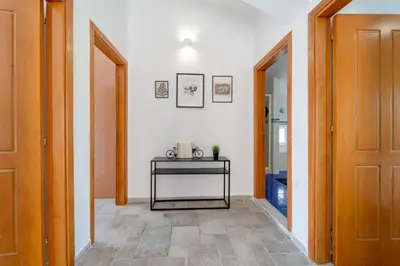 a hallway with a table and two doors at Shady Tree Villa in Ialyssos