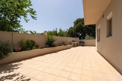 a patio of a house with a fence at Shady Tree Villa in Ialyssos