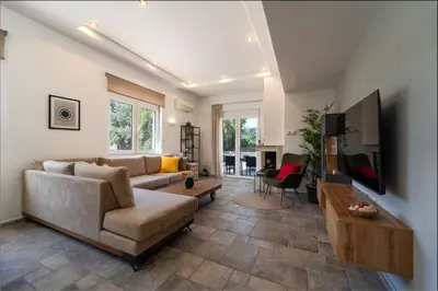 a living room with a couch and a tv at Shady Tree Villa in Ialyssos