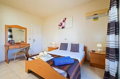 a bedroom with a bed and a desk and a chair at Villa Victoria in Afantou