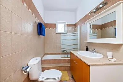 a bathroom with a toilet and a sink and a tub at Villa Victoria in Afantou