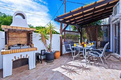 a patio with a grill and a table with chairs at Villa Victoria in Afantou