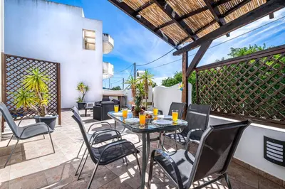 a patio with a table and chairs and a fence at Villa Victoria in Afantou
