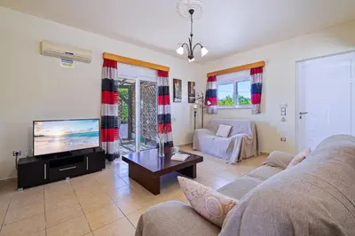 a living room with a couch and a tv at Villa Victoria in Afantou