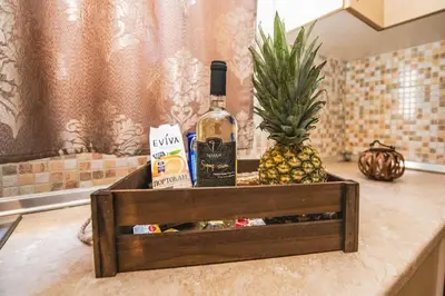 a bottle of wine and a pineapple on a counter at Ntina's Apartment in Rhodes Town