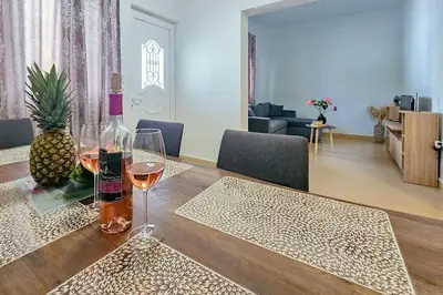 a table with two glasses of wine and a pineapple at Ntina's Apartment in Rhodes Town