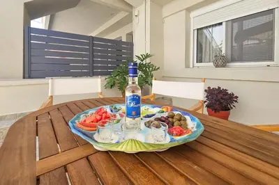 a table with a bottle of wine and a plate of food at Ntina's Apartment in Rhodes Town