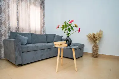 a living room with a blue couch and a table at Ntina's Apartment in Rhodes Town