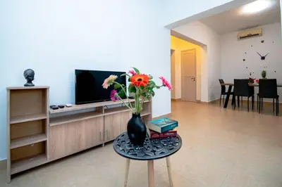 a living room with a vase with flowers on a table at Ntina's Apartment in Rhodes Town