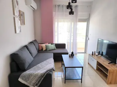 a living room with a couch and a tv at M&K house in Rhodes Town