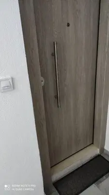 a wooden door with a metal handle on a wall at M&K house in Rhodes Town