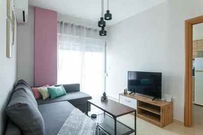a living room with a couch and a tv at M&K house in Rhodes Town