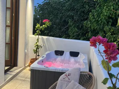 a jacuzzi tub on a balcony with flowers at Vetus Vicinato Luxury Homes in Rhodes Town