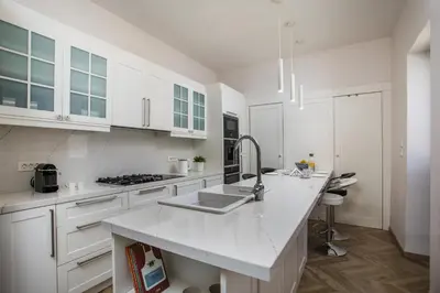 a white kitchen with white cabinets and a sink at Villa Lou in Rhodes Town