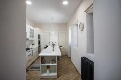 a white kitchen with a sink and a counter at Villa Lou in Rhodes Town