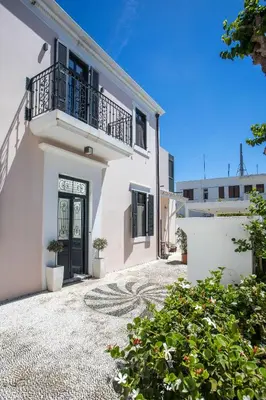 a white house with a balcony and a driveway at Villa Lou in Rhodes Town