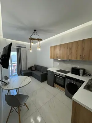 a kitchen and living room with a couch and a table at Cozy City Center Apartment B in Rhodes Town