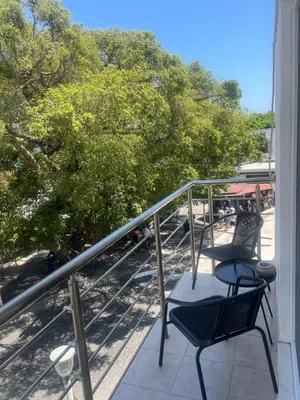 two chairs on a balcony with a view of trees at Cozy City Center Apartment B in Rhodes Town