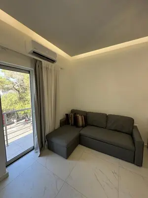 a living room with a couch and a large window at Cozy City Center Apartment B in Rhodes Town