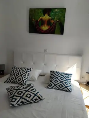 a bed with two pillows and a painting on the wall at Casa Marina in Archipolis