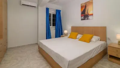 a bedroom with a large bed with blue curtains at Casa Marina in Archipolis