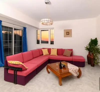 a living room with a red couch and a table at Casa Marina in Archipolis