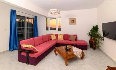 a living room with a red couch and a table at Casa Marina in Archipolis
