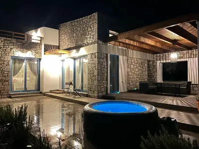 a large room with a swimming pool at night at Anasa Rustic Villa in Kolimbia