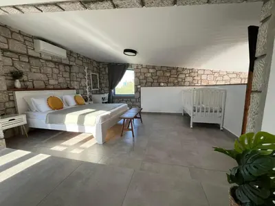 a bedroom with a bed in a stone wall at Anasa Rustic Villa in Kolimbia