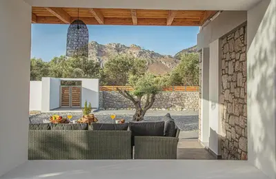 a dining room with a view of a house at Anasa Rustic Villa in Kolimbia
