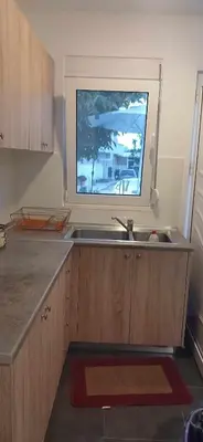 a kitchen with a sink and a window above it at Tsampikas House in Faliraki