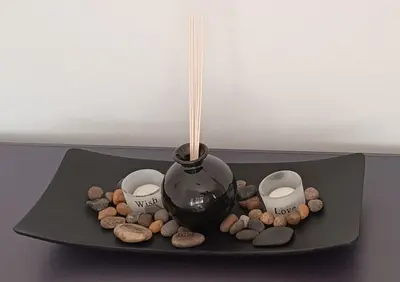 a black plate with a vase and candles and rocks at Pap's House in Rhodes Town