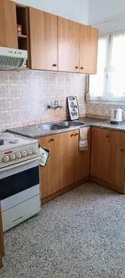 a kitchen with wooden cabinets and a white stove top oven at Pap's House in Rhodes Town