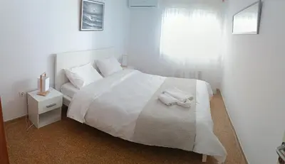 a white bedroom with a white bed and a window at Pap's House in Rhodes Town