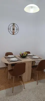 a dining room table with chairs and a clock on the wall at Pap's House in Rhodes Town
