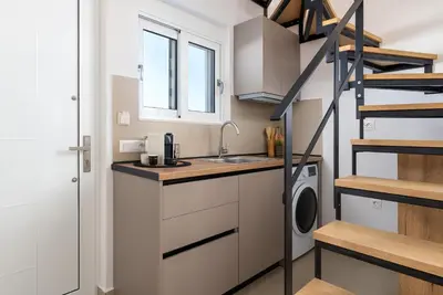 a kitchen with a sink and a washing machine at Amora Pool Villas in Gennadi