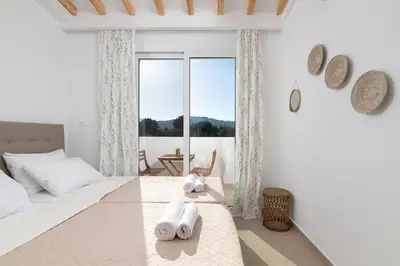 a white bedroom with a bed with towels on it at Amora Pool Villas in Gennadi