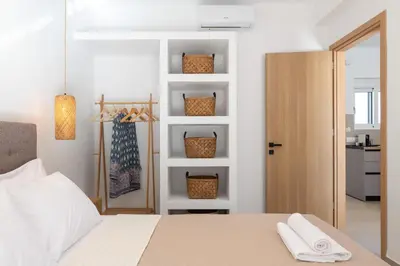 a bedroom with a bed and a door with towels at Amora Pool Villas in Gennadi