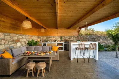 a patio with a couch and a table and chairs at Amora Pool Villas in Gennadi