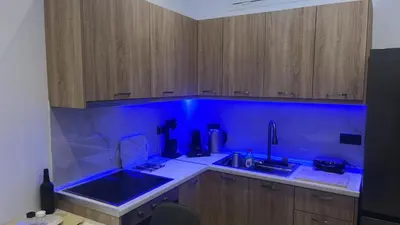 a kitchen with blue lighting in a kitchen with wooden cabinets at Villa Chris - Malona in Malona Village