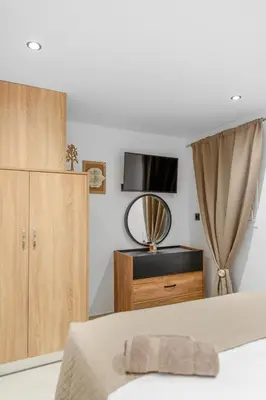 a bedroom with a bed and a dresser and a television at Villa Chris - Malona in Malona Village