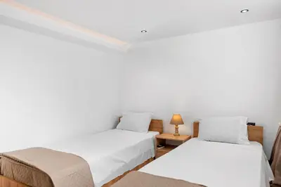 two beds in a room with white walls at Villa Chris - Malona in Malona Village